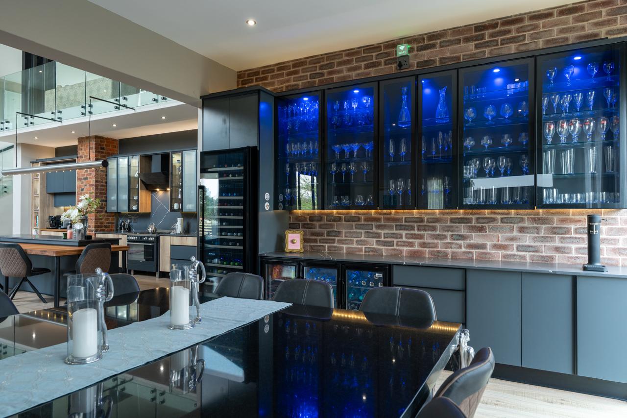 Integrated dining room display cabinetry with blue lighting by Lé Grandt Woodcraft