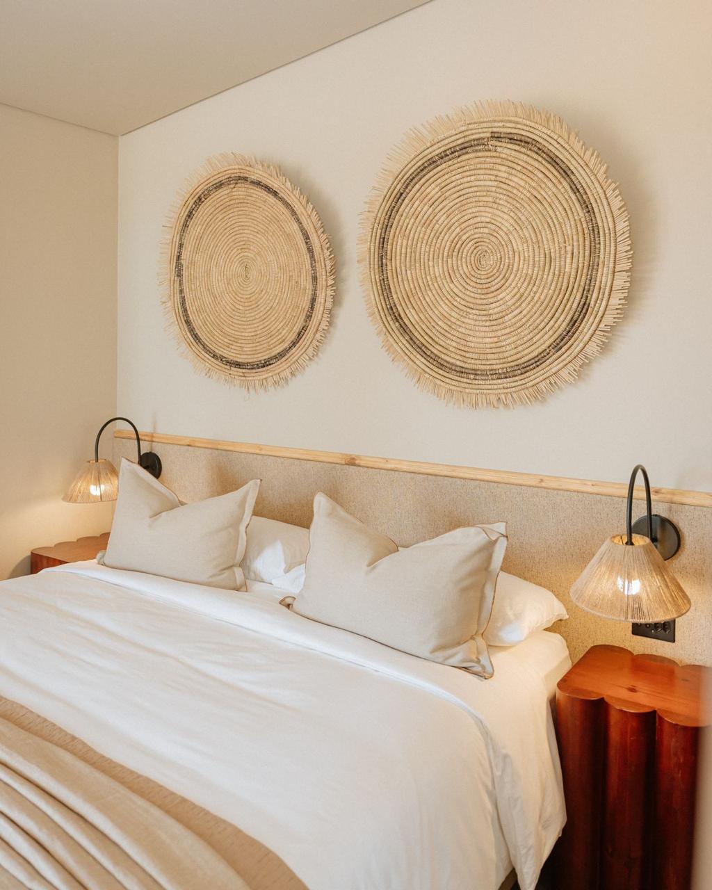 Calm neutral bedroom with woven wall art and timber bedside tables