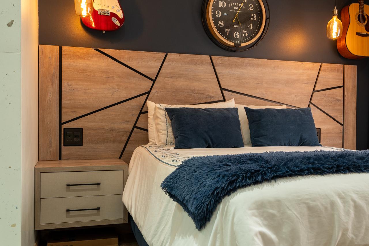 Custom timber headboard with geometric detailing and bedside storage