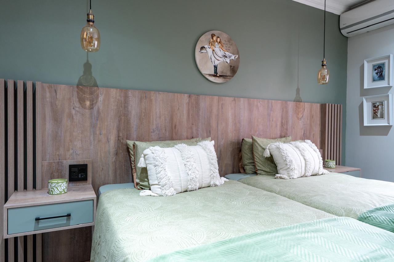 Twin bedroom with sage finishes and a custom timber headboard